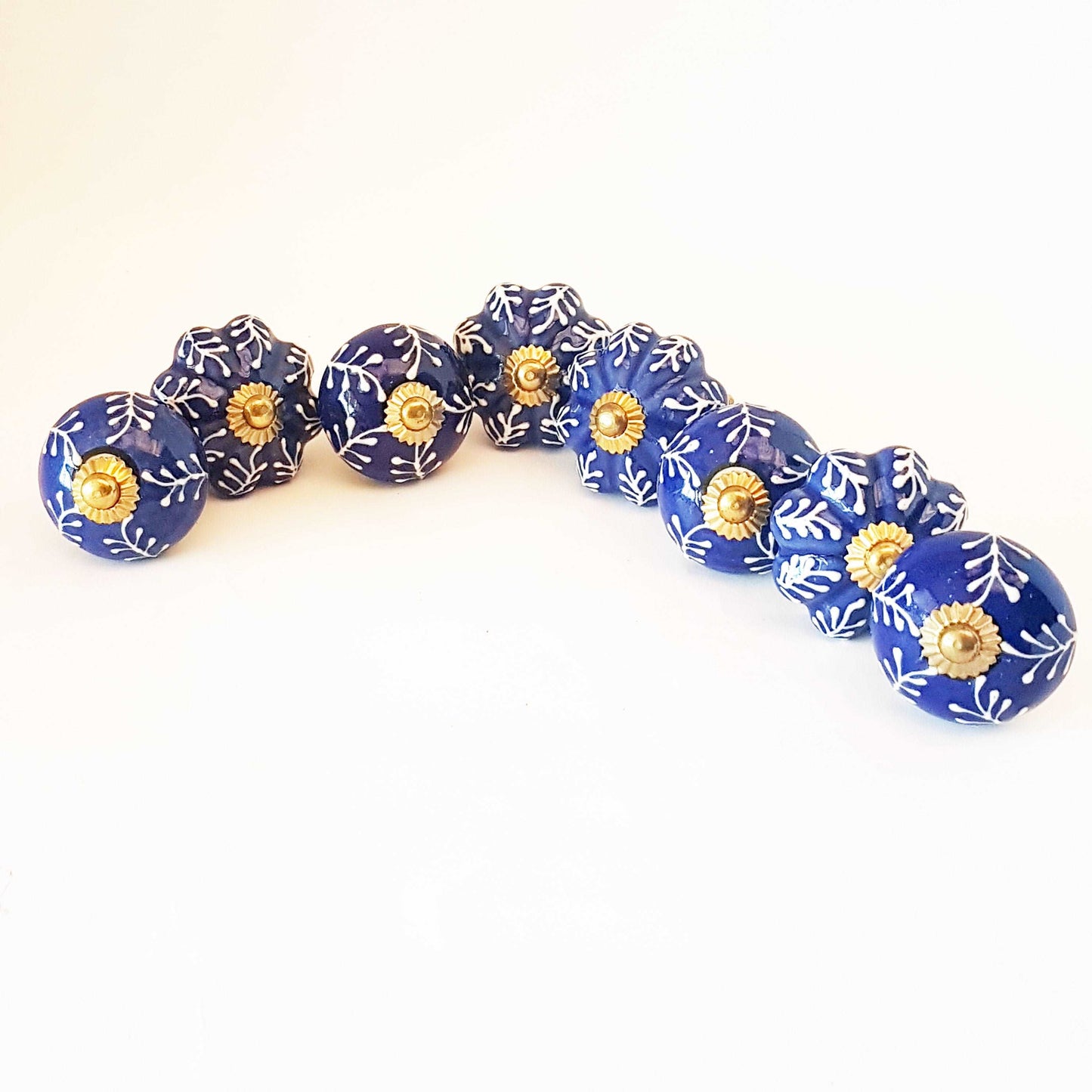 8 Delft cabinet knob drawer pulls in cobalt blue & white hand painted embossed designs. Exclusive Regal Gold  8 piece decorator collection.