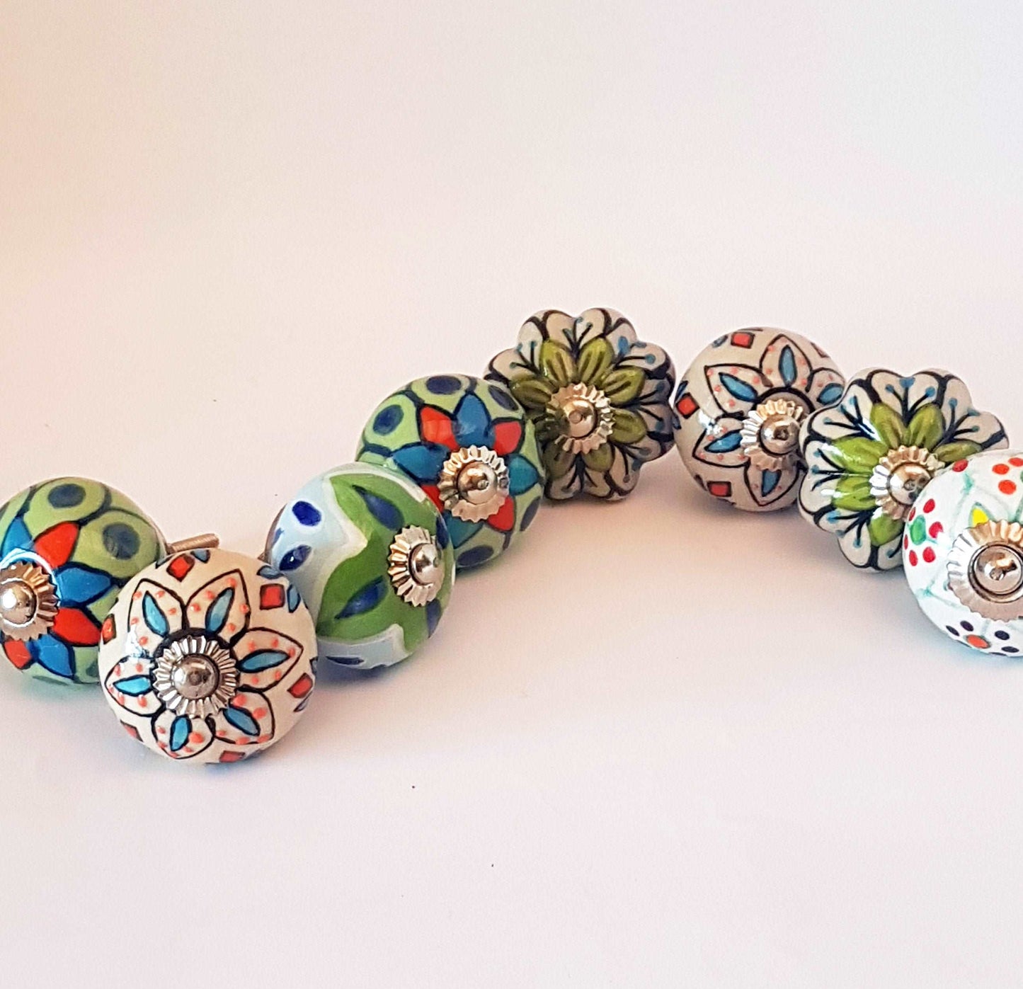 8 hand painted drawer pull cupboard knobs. Exclusive hand painted 8 piece set in blue, green & white floral patterns with silver centers.