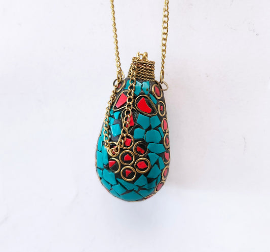 Perfume bottle pendant in a stone mosaic design. Inlaid with Tibetan turquoise. Bottle closes with a brass wand stopper.