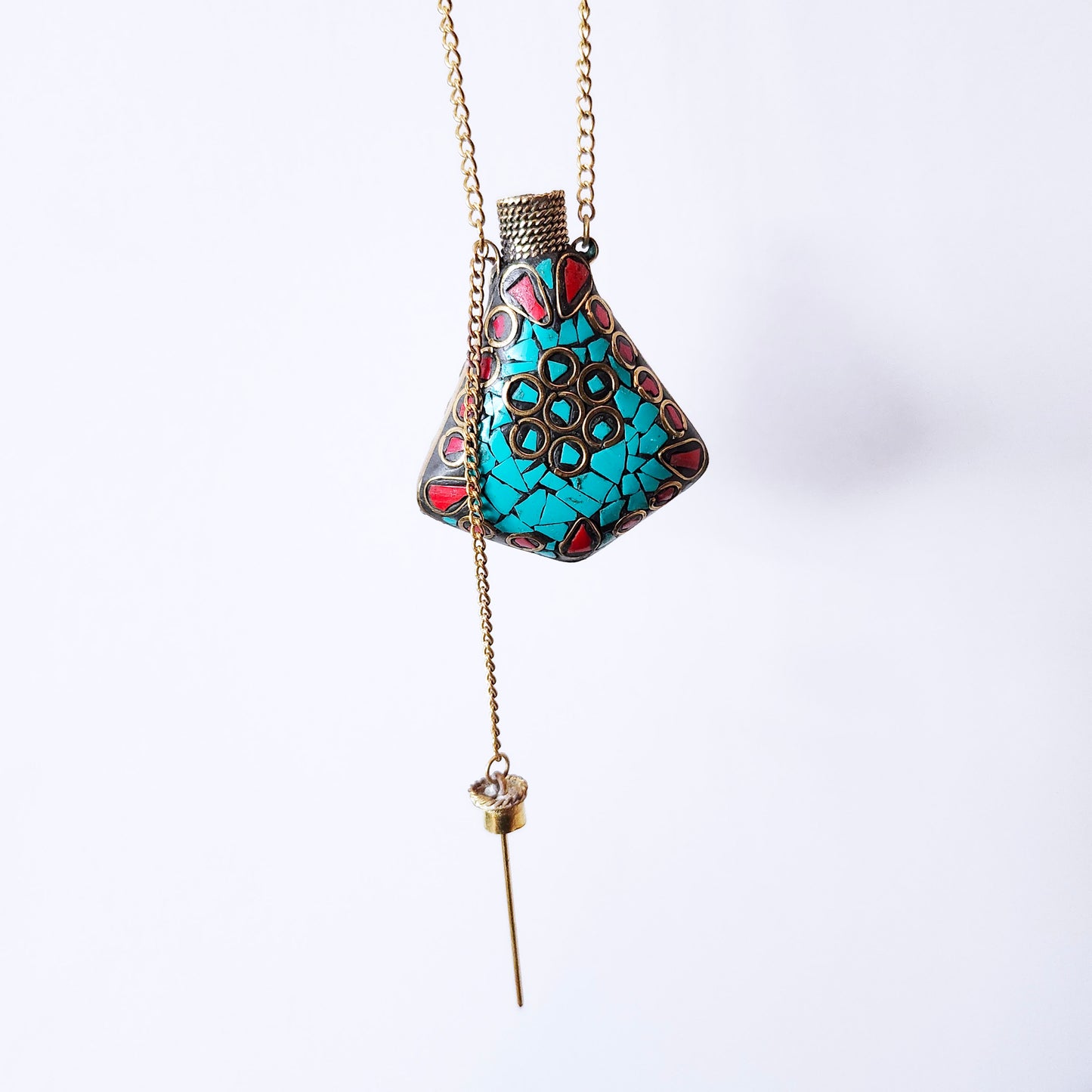 Pendentif bouteille de parfum en mosaïque de pierre. Incrusté de turquoise tibétaine. La bouteille se ferme avec un bouchon en laiton.