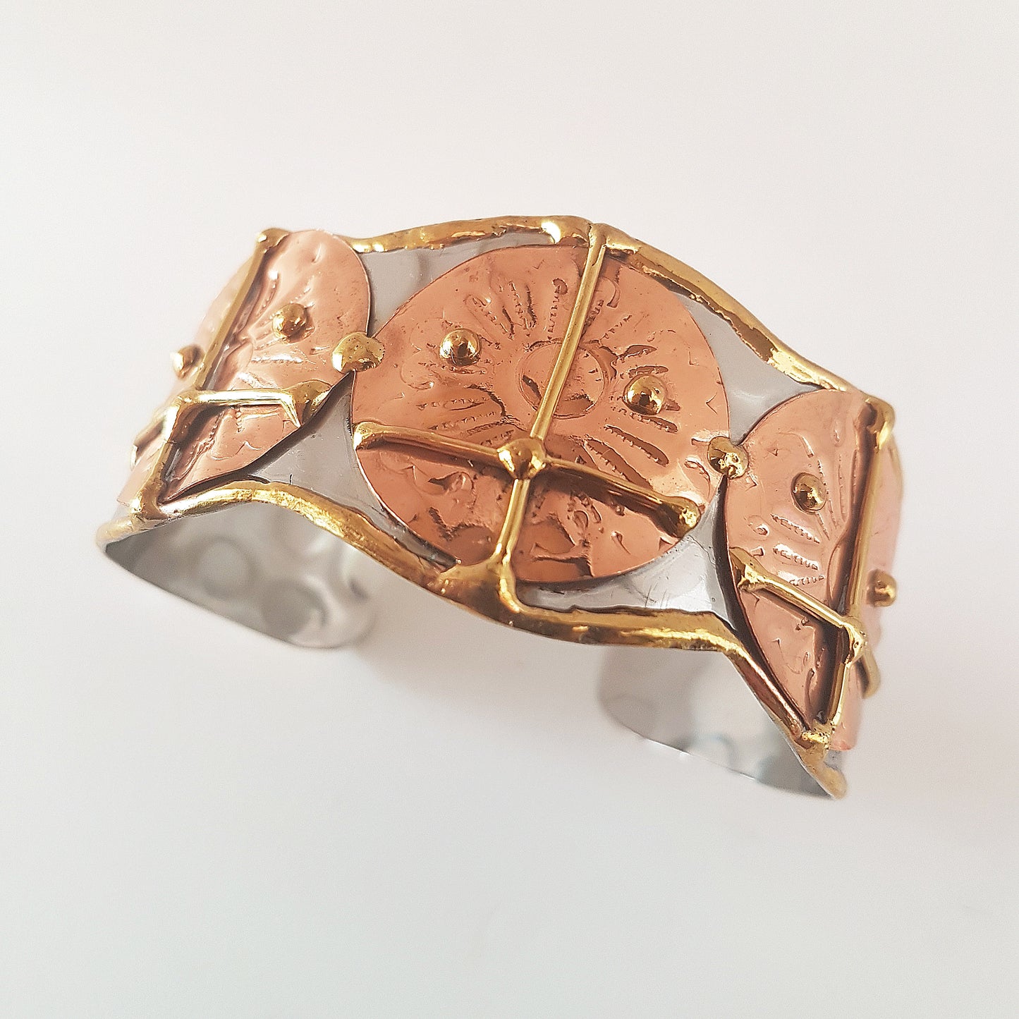 Silver cuff bracelet with a hammered mixed metal design.