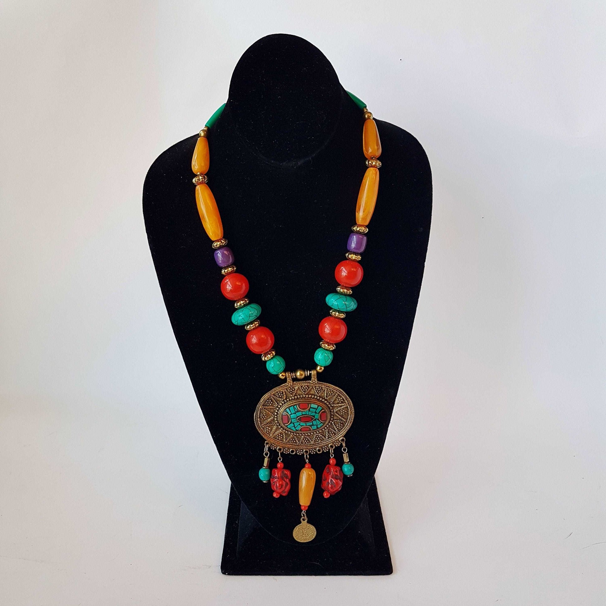 Bohemian designer necklace with amber turquoise and coral beads. Vintage feel embossed bronze metal pendant. Impressive colorful piece. - Vintage India Ca