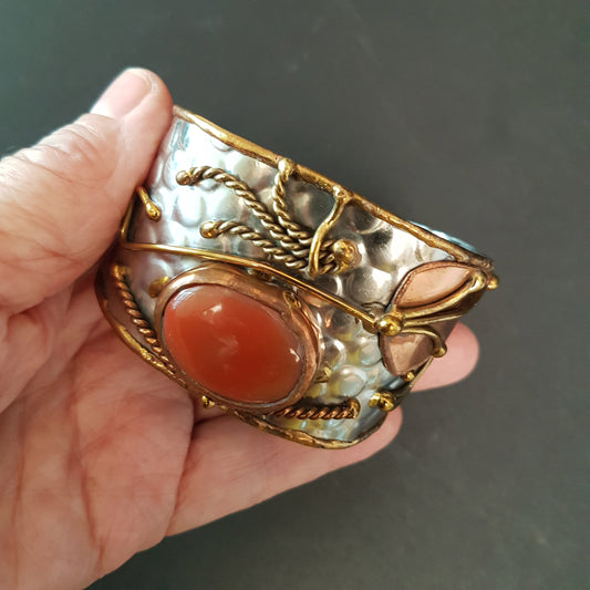 Vintage silver cuff bracelet with a large oval carnelian stone. Celtic trimetal medieval handwrought design. Copper & brass on silver metal.