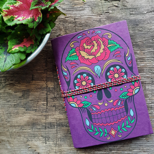 Purple skull sketchbook journal 5 by 7 inches with blank artisan paper pages. Colorful gothic day of the dead sugarskull design in purple.