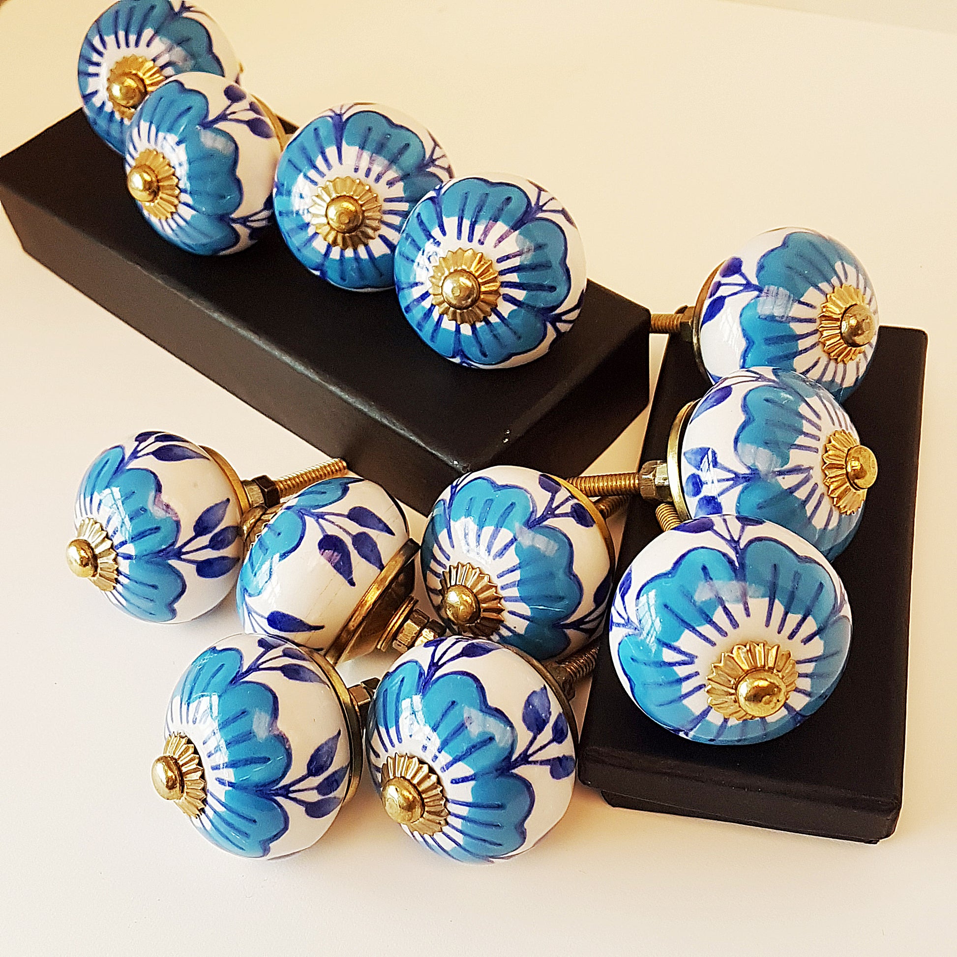 Set of 12 blue & white floral cabinet knobs with gold tone hardware.