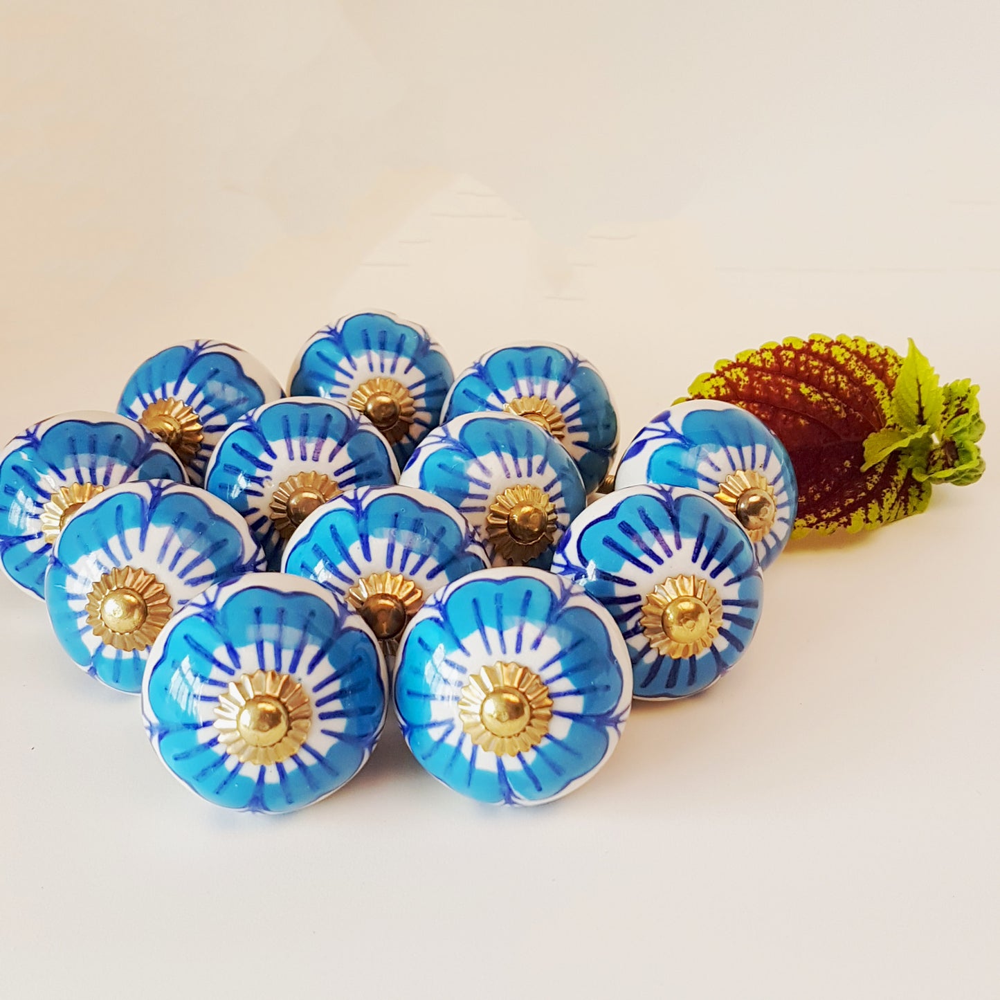 Ensemble de 12 boutons d'armoire à fleurs bleues et blanches avec quincaillerie dorée.