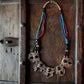 Collier indo-tibétain dramatique avec des pierres d'onyx noires incrustées sur du métal argenté gaufré. Finition corde perlée multicolore.