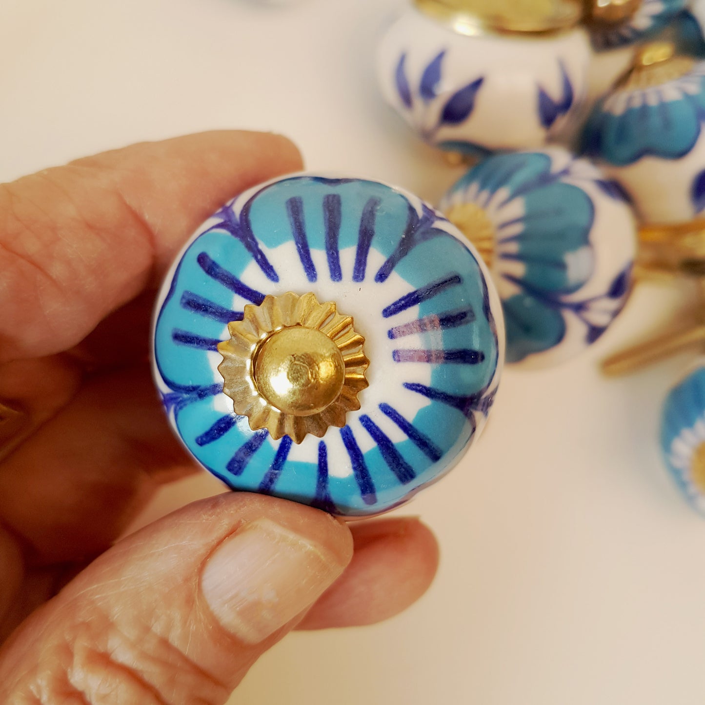 Set of 12 blue & white floral cabinet knobs with gold tone hardware.