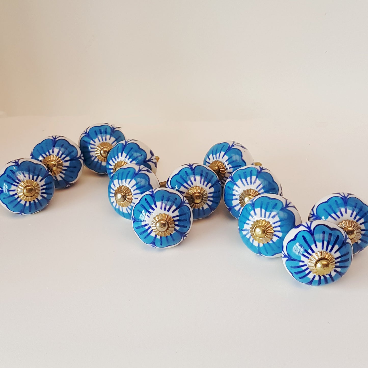 Ensemble de 12 boutons d'armoire à fleurs bleues et blanches avec quincaillerie dorée.