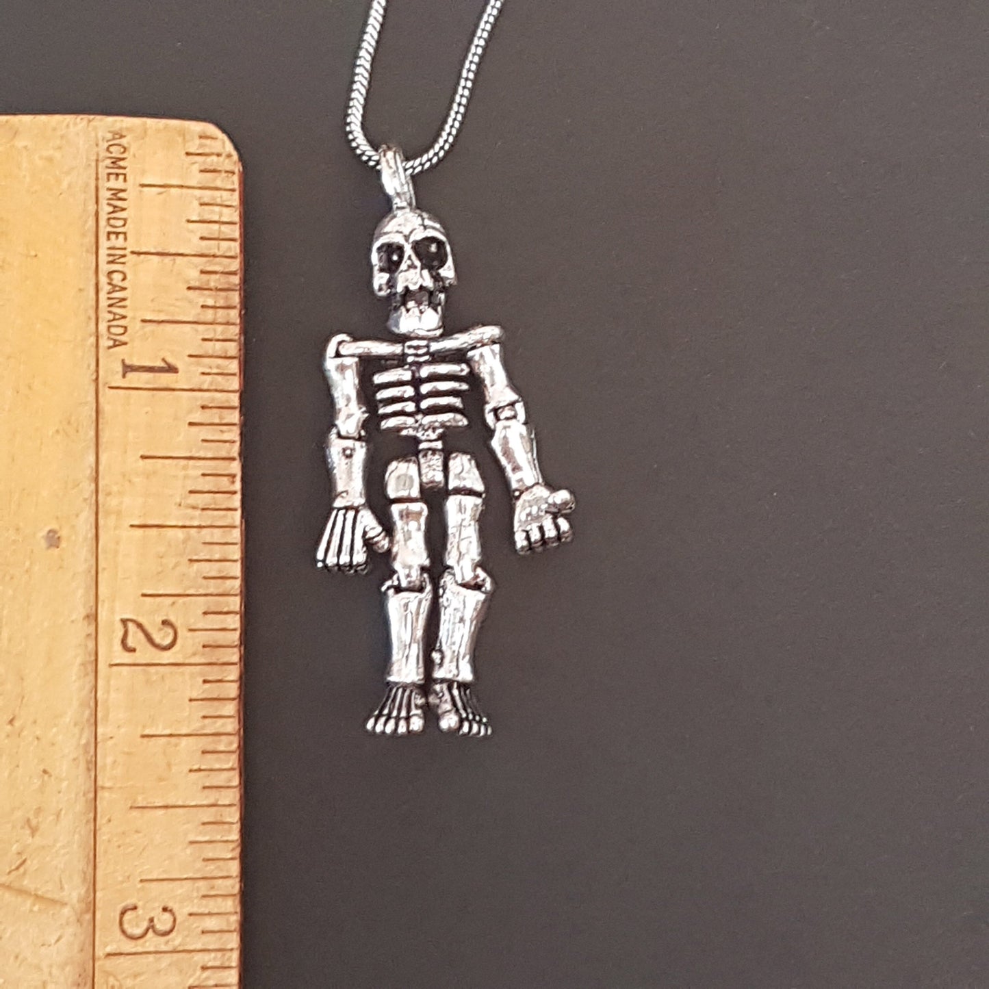 Halloween skeleton pendant necklace on 20 inch chain. Moveable arms and legs. Articulated limb skeleton puppet pendant. Gold & silver. - Vintage India Ca